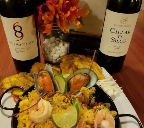 Botellas de vino junto a un plato de comida